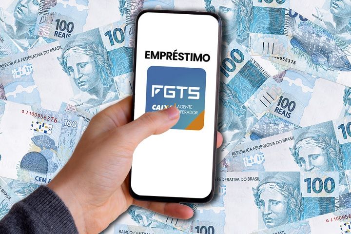 Pessoa segurando celular com tela exibindo opção de empréstimo para negativado com FGTS, sobre fundo de notas de 100 reais.